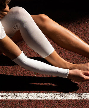 Femme en tenue sportive portant une manchette bras et un tube jambe deuxième peau®, protections textiles contre l’eczéma et les peaux sensibles.